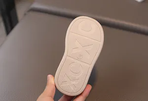Detail of baby sneakers' beige non-slip rubber sole featuring XC pattern and size marking