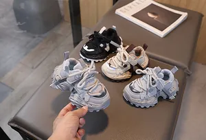 Zapatillas de malla transpirable para niños en tres colores sobre un banco gris