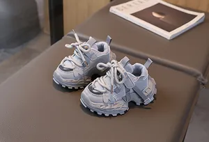 Detalle de zapatillas grises para niños con malla transpirable y suelas de goma