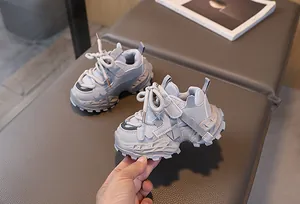 Vista detallada de zapatillas de malla gris para niños con flores y suelas gruesas