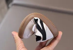 Close-up of flexible rubber sole on children's leather sneakers showing high flexibility