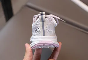 Vue macro de baskets respirantes en mesh rose pour enfants avec bande de mode