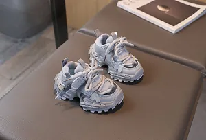 Primer plano de zapatillas grises para niños con malla y suelas dentadas gruesas
