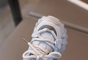Primer plano de zapatillas infantiles con malla transpirable y puntera reforzada antichoque