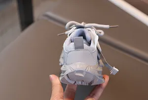 Detalle de zapatillas grises para niños con malla transpirable y suela gruesa antideslizante