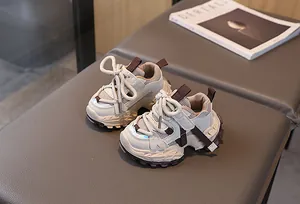 Detalle de zapatillas deportivas infantiles en malla transpirable beige y marrón