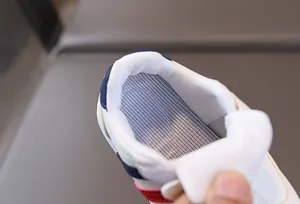 Detail of children's white sneaker showing breathable blue honeycomb mesh insole