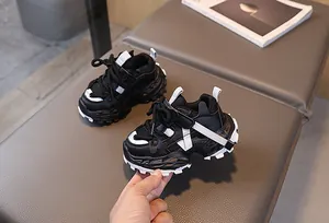Vista detallada de zapatillas chunky transpirables en malla blanca y negra infantil