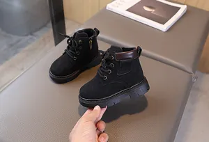 Close-up of black suede children boots with non-slip lug sole and side zipper detail