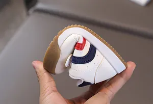 Close-up of highly flexible rubber sole on white leather baby sneakers for toddlers