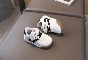 Detail of white toddler sneakers with Velcro strap and non-slip rubber outsole