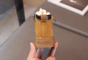 Detail of warm white fleece lining and side zipper on yellow winter boots for kids