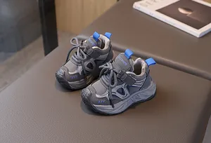 Detail of grey and royal blue kids' sneakers with velcro straps and fashion lettering
