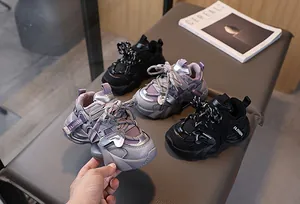 Detailed view of children's thick-soled chunky sneakers in grey and black faux leather