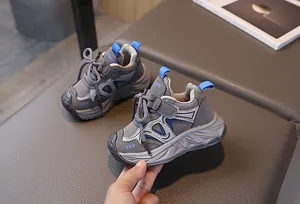 Detail of grey kids sports sneakers with blue accents, rubber sole and velcro strap