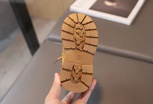 Detailed view of non-slip rubber sole on children's boots showing size 23 and grip