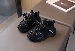 Top view of black children's chunky sneakers with mesh panels and textured leather details