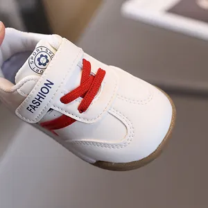 Toddler white leather sneakers with red laces and non-slip rubber soles for babies