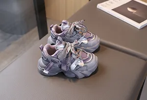 Detail view of children's fashion sneaker featuring purple panels and side webbing strap