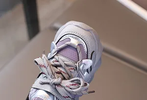Detailed close-up of silver and purple kids sneakers with textured synthetic leather