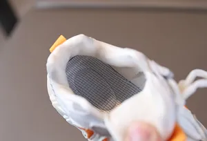 Detailed macro view of breathable mesh insole and cushioned heel lining in kids' sports shoes
