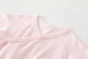 Detail of baby bodysuit neckline with breathable mesh fabric and pink snap buttons
