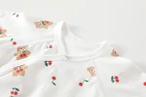 Detail of baby cotton bodysuit featuring button closure and bear cherry print