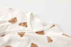 Detail of newborn cotton bodysuit featuring brown bear prints and snap button collar