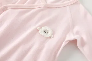 Detail of pink bamboo fiber baby bodysuit with snap buttons and sheep embroidery