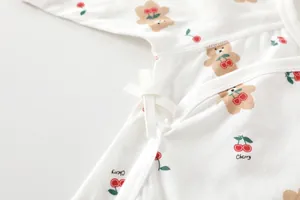 Detail of baby cotton bodysuit featuring side-tie closure and cute cherry bear prints