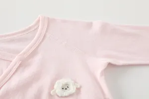 Detail of pink bamboo fiber baby bodysuit with pointelle texture and sheep patch