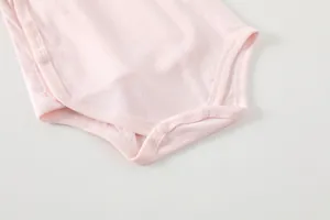 Detail of pink bamboo fiber baby bodysuit showing breathable fabric texture and snap buttons