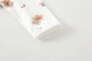 Detail view of cotton baby bodysuit sleeve with bear and cherry prints and fine stitching