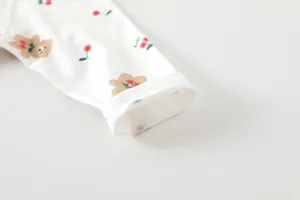 Detail of baby bodysuit sleeve with bear print and premium double stitching