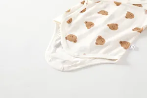 Detail of baby cotton bodysuit featuring bear prints and resin snap buttons for diapering