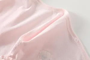 Close-up of light pink baby romper with breathable pointelle knit fabric and snap button