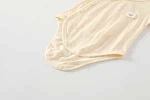 Détail d'un body bébé en fibre de bambou avec broderie mouton 3D et boutons-pression