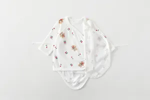 Detail of newborn cotton bodysuit featuring brown bear and cherry prints with tie closures