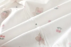 Macro shot of soft cotton newborn bodysuit fabric with cute cherry and bear patterns