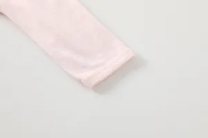 Close-up detail of soft pink bamboo fiber knit cuffs on breathable baby bodysuit