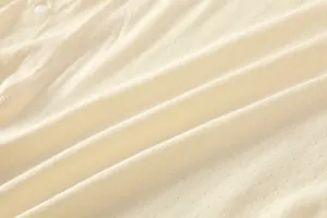 Détail d'un body bébé en fibre de bambou avec tissu jacquard respirant et bouton pression