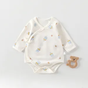 Detail of soft cotton baby romper with blue milk bottle prints and side tie closure