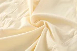 Détail du tissu jacquard respirant en fibre de bambou sur le body bébé avec petit bouton