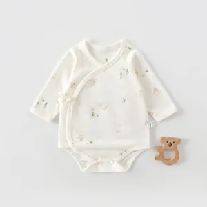Detail of newborn cotton bodysuit with delicate duck print and side-tie bow closure