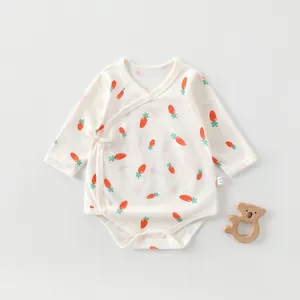 Detailed flat lay of newborn cotton romper with carrot print and side tie-up design
