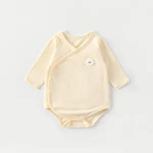 Detail of bamboo fiber baby bodysuit with button closure and 3D sheep embroidery