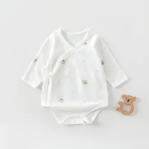 Detail of newborn cotton bodysuit featuring side ties and sun print on white fabric