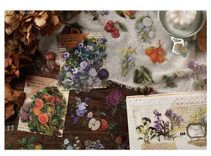 Dettaglio di adesivi PET botanici con melograni e motivi floreali su legno vintage