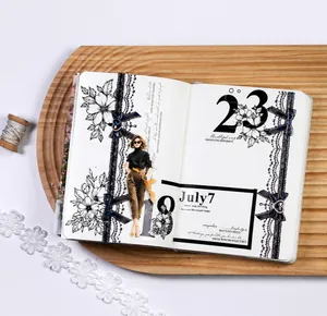 Detailed view of black lace decorative tape and floral stickers on a vintage journal page