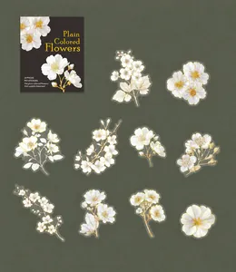 Detail of white flower stickers with gold foil accents on dark green textured background